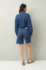 Bermuda de jean azul de corte clásico y largo a la rodilla.