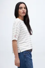 Remera holgada a rayas horizontales color crudo y beige, con mangas cortas y tajos laterales.