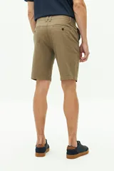 Bermuda de gabardina color verde militar, con bolsillos laterales y traseros, cierre con cremallera y botón, y trabillas para cinturón.