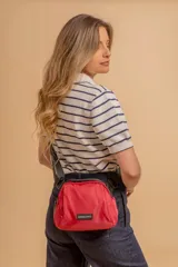 Bandolera pequeña de tela negra, con correa ancha ajustable y cierre superior.