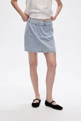 Minifalda de jean celeste con detalle de ojales metálicos en la cintura.