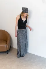 Pollera larga de viscosa con estampado de lunares blancos sobre fondo negro.
