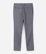 Pantalón de vestir gris, de corte slim fit, con bolsillos laterales y traseros. Se ajusta a la cintura con cinturón de cuero negro.