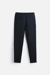 Pantalón negro de corte cropped, con cintura elástica ajustable con cordón, bolsillos laterales y traseros de vivo. El bajo tiene terminación con vuelta.