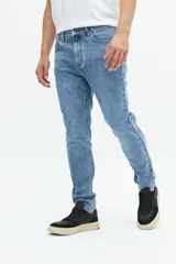 Jean slim azul oscuro, tiro medio, con pasacintos y confeccionado en 98% algodón y 2% spandex.