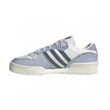 Zapatillas urbanas Adidas Rivalry Low, color blanco con detalles en celeste y azul marino. Confeccionadas en cuero y gamuza, con las tres tiras características de la marca en los laterales.
