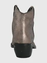 Botín de cuero metalizado color peltre, con puntera fina, caña baja y taco cuadrado.