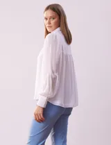 Camisa celeste de gasa, marca Tahari. Cuello con solapa y abertura central con botones ocultos. Manga larga abullonada con puño y botones. Forro de gasa a tono.