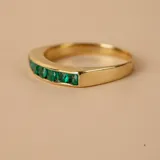 Anillo de oro amarillo 18k con esmeraldas engarzadas.