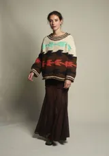 Sweater de lana tejido a mano con diseño abstracto en tonos beige, marrón, naranja, celeste y negro. De calce holgado, con cuello redondo y puños acanalados.