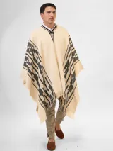 Poncho tejido color ladrillo con diseño geométrico en negro y flecos en el ruedo.