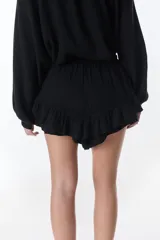 Short pollera blanco de tela arrugada con volados y detalles de encaje.
