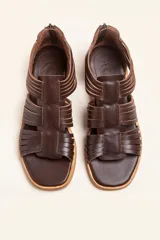 Sandalia de cuero color chocolate con tiras entrecruzadas y cierre trasero con cremallera.