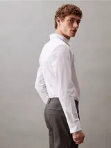 Camisa blanca de algodón, poliéster y elastano, de corte slim, manga larga y cuello en punta.