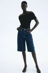 Top negro con textura, corte ajustado y escote off-the-shoulder con volantes.