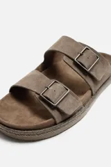 Sandalias marrones de piel con doble tira ancha en el empeine y cierre mediante hebilla. Plantilla con horma anatómica y suela forrada de yute.