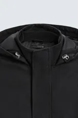 Parka negra de tejido técnico acolchado, corte regular fit, cuello alto con capucha ajustable, manga larga con puños ajustables, bolsillos de solapa en la cadera y bolsillo interior. Cierre frontal con cremallera oculta y botones a presión.