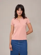 Remera polo de piqué color salmón con cuello clásico y tapeta de botones.