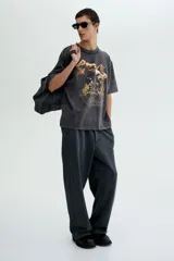 Remera gris con efecto lavado, corte holgado, cuello redondo y estampado de un águila, cactus y texto "Rodeo Sunset".