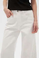 Pantalón de jean blanco de corte ancho y tiro alto, con bordados de strass plateado en los laterales.