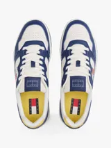 Zapatillas Tommy Jeans de corte bajo, confeccionadas en piel color blanco y azul con detalles en amarillo. Presentan suela cupsole, detalle de ventilación en la parte superior, logo de Tommy Jeans en relieve en la entresuela y parche de Tommy en el lateral.