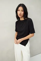 Remera negra de manga corta, con cuello recto y terminación en pico.