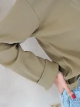 Remera negra de manga larga con cuello redondo. Jeans de tiro alto color celeste con cinturón con hebilla dorada. 