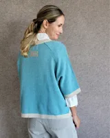 Sweater rosa de lana con cuello redondo y puños y ruedo en color crema.