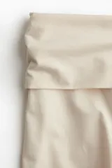 Pantalón de punto color crema, de pierna ancha y cintura alta con detalle drapeado.