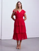 Vestido blanco de gasa con capas de la marca Julia Jordan. Tiene escote en V, mangas cortas con volados, corte en la cintura, abertura central en la espalda con cierre invisible y forro interno a tono.