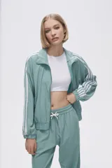 Campera deportiva color verde agua con cierre frontal, cuello alto y tres rayas blancas en las mangas.