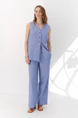 Pantalón de lino a rayas verticales azules y beige, de corte recto y relajado.