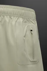 Shorts de entrenamiento negros confeccionados en tejido técnico ligero y elástico, con cintura elástica ajustable con cordón interior, bolsillos frontales y bolsillo trasero con cierre de cremallera. Bajo con acabado termofijado y aberturas laterales.
