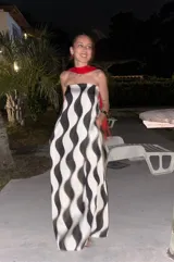 Vestido largo strapless con estampado abstracto en blanco y negro, con elástico en la parte trasera y bolsillos laterales. Incluye una pieza de tela roja para usar como chalina.