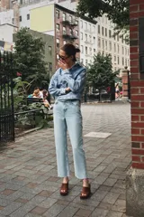 Pantalón de jean color crudo, de tiro alto, corte recto y largo tobillero. Tiene cinco bolsillos, cierre frontal con cremallera y botón metálico.