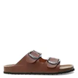 Sandalias planas color beige con dos tiras anchas con hebillas metálicas plateadas.