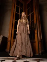 Vestido largo color marrón con bordados florales a tono, escote en V y corte imperio. Tiene falda amplia con volados y breteles finos.