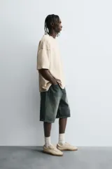 Camiseta color beige de corte holgado, cuello redondo y manga corta.