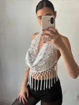 Top halter blanco con lentejuelas plateadas y flecos.