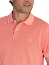 Chomba color salmón de piqué de algodón orgánico, con cuello clásico y tapeta de dos botones.