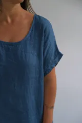 Vestido azul de lino italiano, corte suelto, escote redondeado, mangas cortas y botones decorativos en los costados.