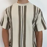 Remera de punto calado color blanco con rayas verticales marrones y negras, corte holgado y mangas cortas.