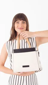 Cartera color beige con doble asa corta y correa larga extraíble. Tiene un bolsillo principal con cierre y varios bolsillos interiores.