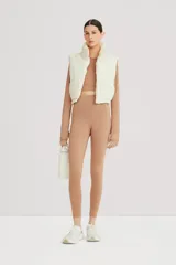 Calza color café de tiro alto, realizada en tejido suave y ligero, de alta elasticidad.