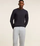 Pantalón de lino blanco de corte recto, con trabillas en la cintura, cierre tradicional y bolsillos laterales.