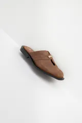 Zuecos con estampado animal print en blanco y negro, con tira ancha de cuero negro y aplique metálico.