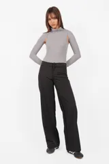 Body gris de tejido de punto con cuello alto y mangas largas. Presenta aberturas en los hombros y broches en la entrepierna.