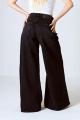 Pantalón de jean negro de tiro alto, corte wide leg y denim rígido.