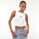 Musculosa blanca de algodón con cuello redondo y sisas amplias. Estampado pequeño en el pecho con motivo playero: palmeras, sol y tabla de surf.