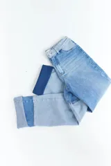 Pantalón de jean con diseño patchwork en diferentes tonos de azul, corte recto y tiro alto.